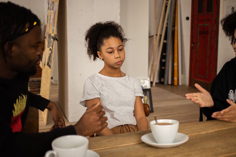 Symbolbild Große Familienentscheidungen: Familie im Gespräch am Tisch