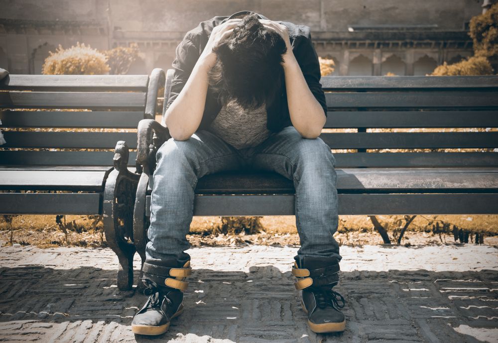 Symbolbild Anhaltende, komplizierte Trauer: Person sitzt allein auf einer Bank