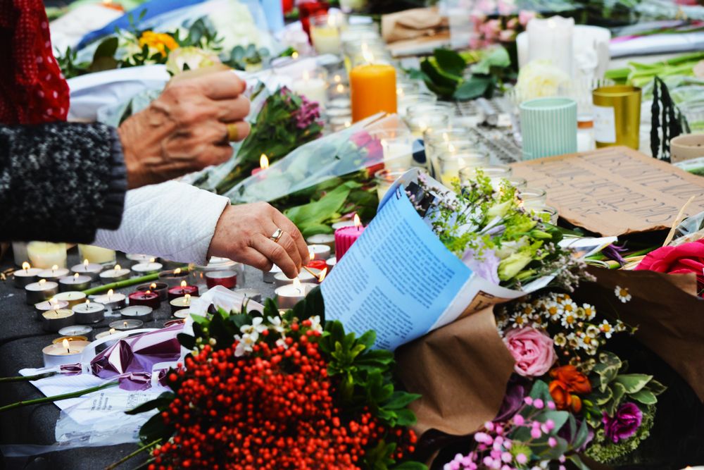 Symbolbild Weltliche Trauerfeier: Kerzen und Blumen bei einer Zeremonie